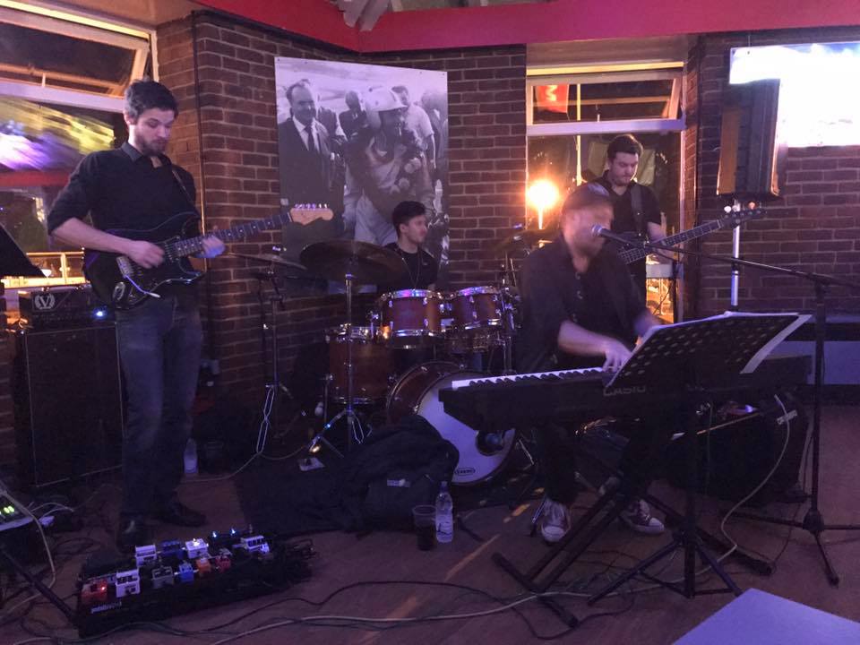 The full band performing live at a venue
