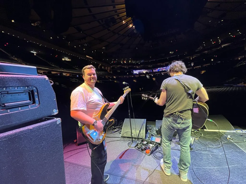 Jack Collier performing on bass on a major arena stage