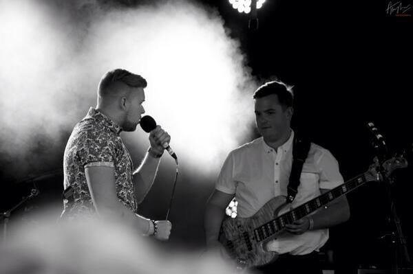 Jack playing bass alongside vocalist Jamie Johnson under stage lights
